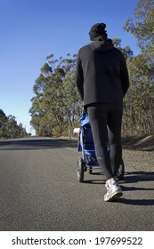 Dad Walking Or Running Pushing With A Baby Stroller In The Country