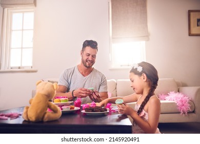 Dad Will Do Anything To Make Her Feel Like A Princess. Shot Of A Father And His Little Daughter Having A Tea Party Together At Home.