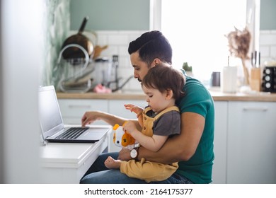 Dad Working On Laptop With Child Sitting On His Lap 