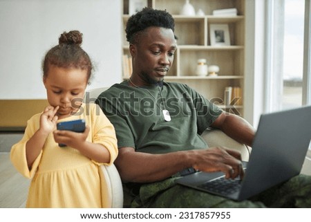Dad working online while sitting with child at home