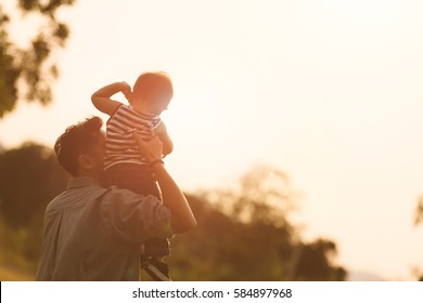 Daddy carrying son on his back at the sunset. - Powered by Shutterstock