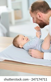 Daddy Cuddling Baby Boy On Changing Table