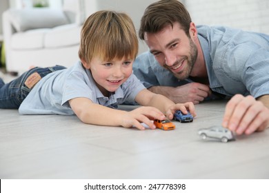 Daddy with little boy playing with toy cars - Shutterstock ID 247778398