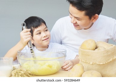 Daddy And Son Making Mashed Potatoes Happily