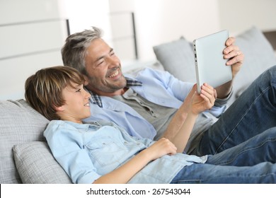 Daddy and son websurfing on digital tablet at home - Powered by Shutterstock