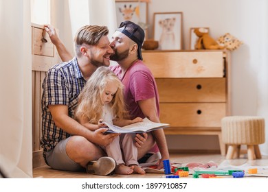 Dads and daughter spend their time reading a book. LGBT family and child's education.