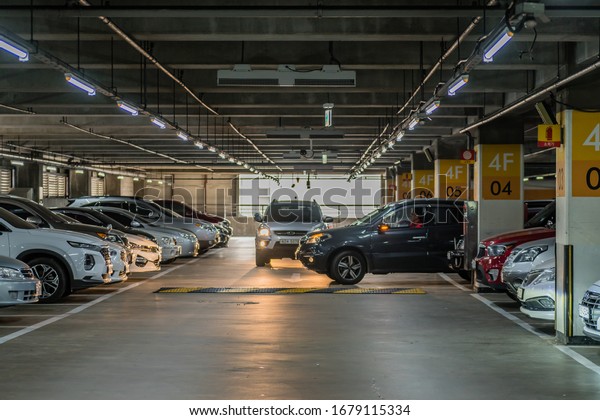 Daejeon,\
South Korea; March 21, 2020: Unidentified man parking car in full\
parking garage at shopping center during COVID-19 outbreak.\
Concept: People not obeying health\
protocols.