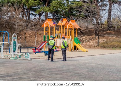 Daejeon, South Korea; March 9,2021: Two Unidentified City Workers Inspect Playground Equipment At Urban Park.