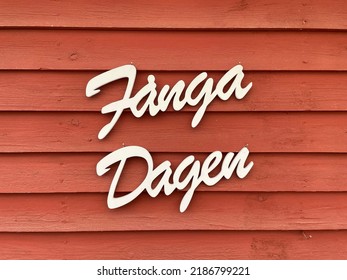 "Fånga Dagen" means "Carpe Diem" in swedish. Written in white text on a red barn wall. 