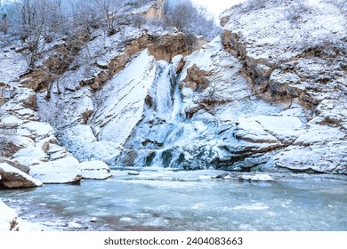 Dagestan landmark, Khuchninsky or otherwise called Khanaga waterfall, 30 meters high. Winter landscape, mountains covered with snow, water frozen and turned into ice - Powered by Shutterstock