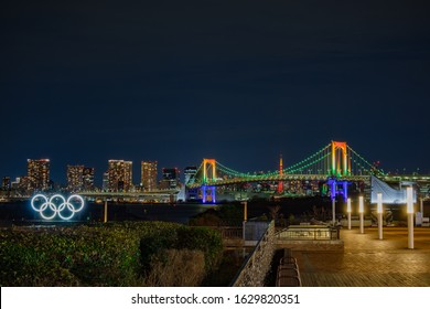 Daiba, Tokyo / Japan - January 24 2020:  Oylmpic Rings / Symbol Illumination Light Up At Rainbow Bridge - Tokyo Bay, Odaiba Marine Park,   Tokyo Summer Olympics 2020 Venue With Tokyo Tower Background