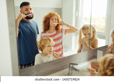 Daily Hygiene. Nice Happy Family Brushing Their Teeth While Doing Morning Hygienic Procedures