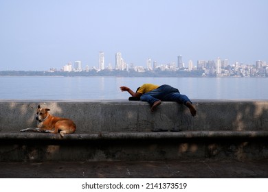 Daily Life - MUMBAI, Maharashtra, India, March 27, 2022. A Man Taking A Power Nap At Nariman Point In South Mumbai, India, Asia