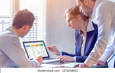 Daily team meeting around agile product development board with scrum or kanban framework, lean methodology, iterative or incremental organization project management strategy for software design - Shutterstock ID 1376318021