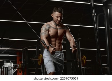 Daily workout session. Muscular man training shirtless in gym indoors. Doing lat pull down exercises. Relief, body shape. Concept of health, sportive lifestyle, fitness, body care, diet, strength - Shutterstock ID 2259075059