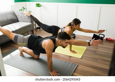 Daily Yoga Exercises. Sporty Young Man And Latin Woman In A Tiger Pose Practicing A Yoga Workout 