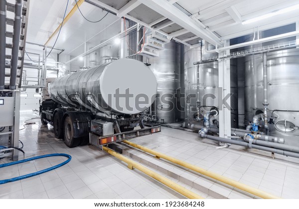 Dairy factory industry, milk tanker truck\
pumps products into steel storage\
tanks.