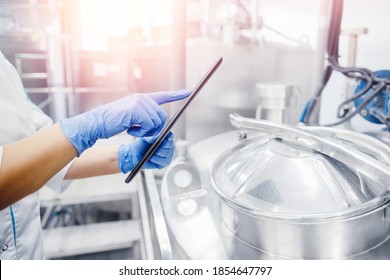 Dairy Factory Production, Engineer Operator Check Quality With Computer Tablet In Milk Tank.