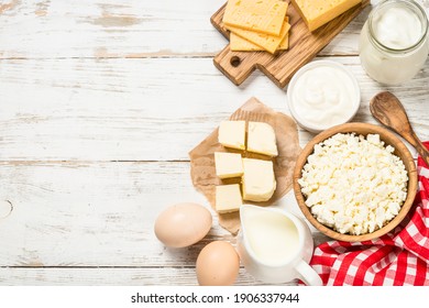 Dairy Product At White Wooden Table. Curd, Milk, Yogurt, Cheese And Eggs. Organic Farmer Food. Top View With Copy Space.