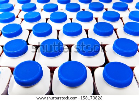 dairy products bottles stand in rows, bright covers