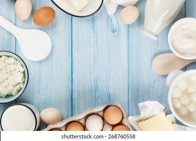 Dairy products on wooden table. Sour cream, milk, cheese, egg, yogurt and butter. Top view with copy space