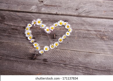 daisies flowers heart shape on wooden table - Powered by Shutterstock