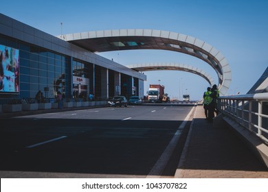 DAKAR, SENEGAL, FEBRUARY 22 2018: Departure Platform On The New Blaise Diagne Airport In Dakar, Senegal On A Sunny Day. Some People, Security Guards And Cars Are Seen Parked.