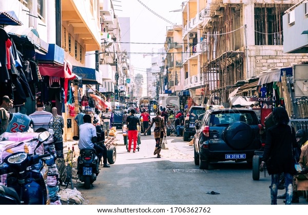 DAKAR, SENEGAL - NOVEMBER 11,\
2019: People working and traffic at Senegal capital Dakar, West\
Africa.
