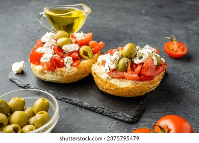 Dakos, Cretan dish with bread, tomatoes, butter, herbs and feta cheese or cottage cheese on a dark background. - Powered by Shutterstock