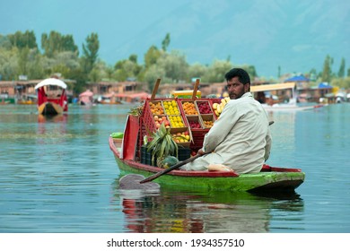 Dal Lake, Srinagar - 21 July 2019 A beautiful picture of a man paddling a boat and selling fruits in Dal lake which is tourist attraction as it is a market place inside a lake.