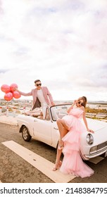 Dalat City, Vietnam - November 2021: Rich Asian Couple Wearing Sunglasses Posing Next To A White Car. Man's Hand Holding A Bunch Of Balloons.