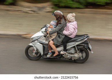 Dalat, Vietnam - May 6th 2015: A Young Mother And Her Two Kids Riding A Motorcycle Without Helmet In Dalat, Vietnam.