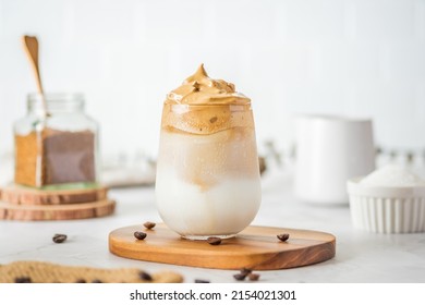 Dalgona coffee with fluffy cream served on wood tray.Homemade trendy beverage menu on social media - Powered by Shutterstock