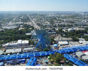 DALLAS, TEXAS—OCTOBER 2017: Aerial View Of The Texas State Fair Carnival Grounds With The Famous Blue Ferris Wheel And Dallas In The Background.