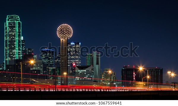 Dallas skyline by night with traffic trails on\
Tom Landry freeway