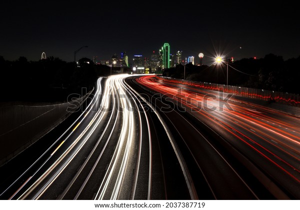 Dallas skyline\
at night with vehicle light\
trails
