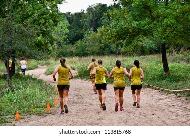 DALLAS, TEXAS - SEPTEMBER 15: Unidentified Team Participants Run Along The Course Near Finish In The Dash Of The Titans Mud Run Race On September 15, 2012 In Dallas, Texas.