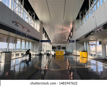 DALLAS, TEXAS, USA - AUGUST 5, 2019: A man  sit on a bench and wait for the train to travel to each terminal in Dallas Fort Worth International Airport. The hall has high ceiling, modern & spacious.