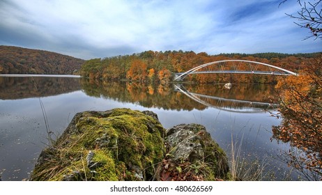 Dam with bridge and rock in autumn