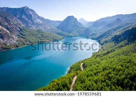 Dam lake in Green Canyon. Beatiful View to Taurus Mountains and turquoise water. Coniferous forest with green pine trees and a road stretching into the distance. Manavgat, Turkey. Turkish landscape