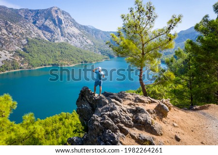 Dam lake in Green Canyon. Beatiful View to Taurus Mountains and turquoise water. Coniferous forest with green pine trees. A man stands on the edge of a cliff. Manavgat, Turkey. Turkish landscape
