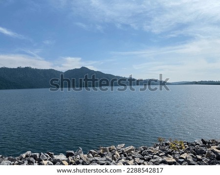 A dam is in nature with water, lakes and mountains, and the summer sky.