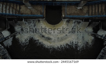 A dam on a reservoir with an open sluice, a small waterfall. Winter