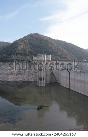 Dam of Sau reservoir (Pantà de Sau) in Catalonia in November 2023 - The water level is extremely low due to the dry and hot summer. The remaining water is moldy. The dam was finished in 1962.