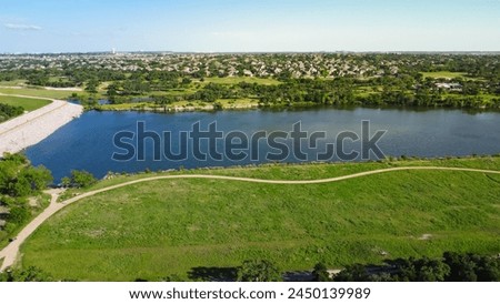 Dam sites at upper Brushy Creek Lake Park next master-planned community in Brookside neighborhood near Austin, 90-acre lush greenery area, nature trails, people enjoy picnic activities, aerial. USA