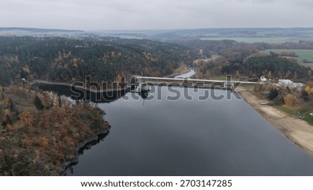 Dam structure with control building and spillway in autumn forest landscape. Perfect for engineering background or environmental report - Listany, Czech - Nov,8,2025