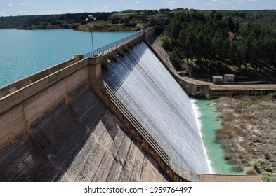 Dam In A Swamp Pouring Water Overhead. Vegetation And Trees