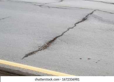 Damage To The Roadway. A Transverse Crack On The Asphalt Surface. Road Safety, Repair Work.