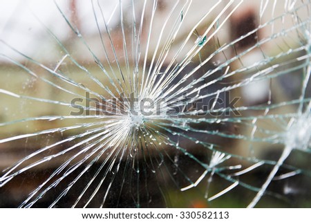 damage, violence, vandalism and danger concept - broken glass with cracks