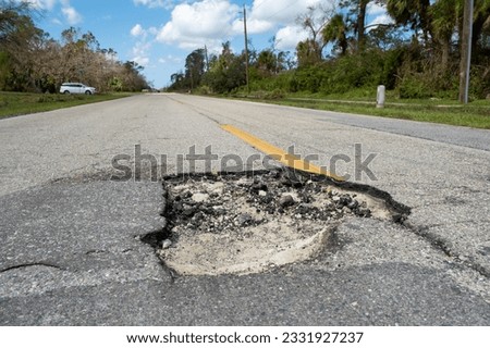 Damaged american road surface with deep pothole. Ruined street in urgent need of repair Stock photo © 